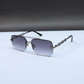 Rimless square sunglasses with a dark gunmetal metal frame and gradient gray lenses, displayed on a white surface with a dark gray background.